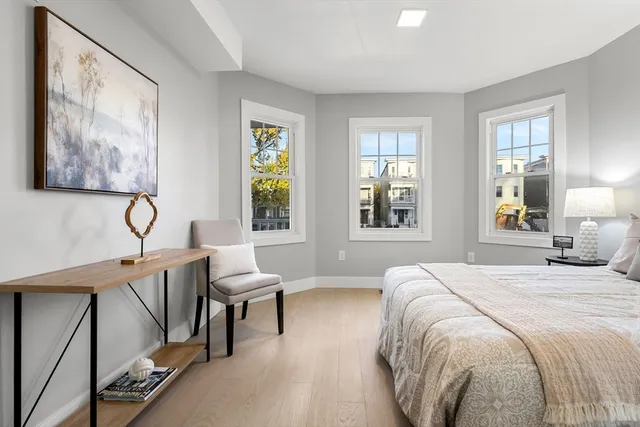 a bedroom with a bed and wooden floor