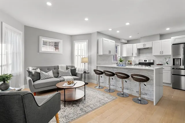 a living room with furniture and kitchen view