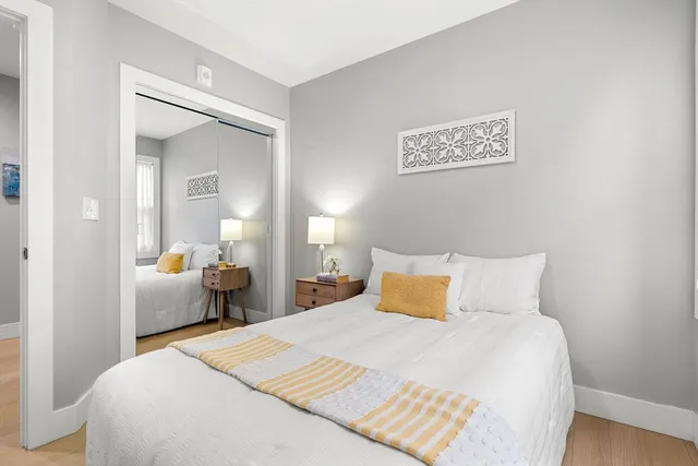 a bedroom with a bed and wooden floor