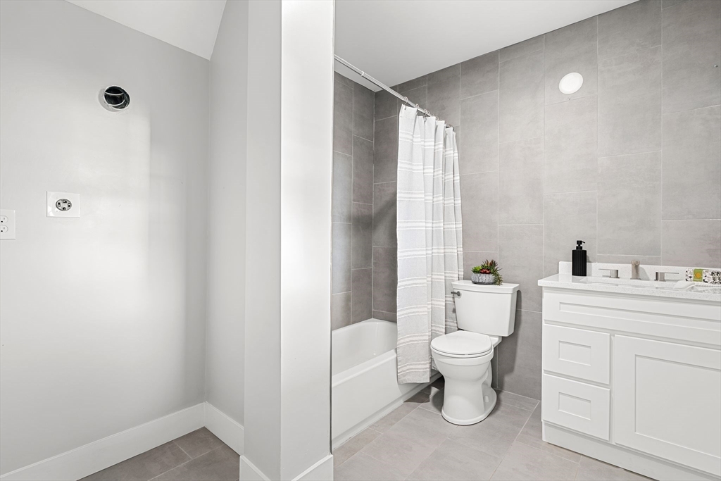 679-683 Columbia Road, Unit 1 Boston, MA 02125 - Photo 27 of 31 a bathroom with a toilet sink and a mirror