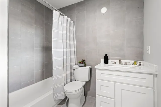 a bathroom with a sink toilet vanity and tub