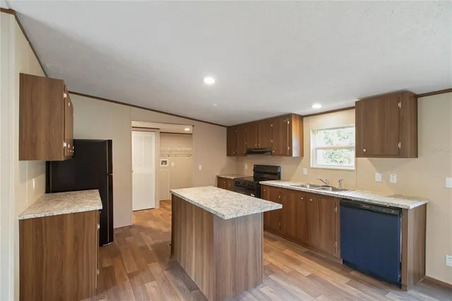 a kitchen with a sink a counter top space and stainless steel appliances