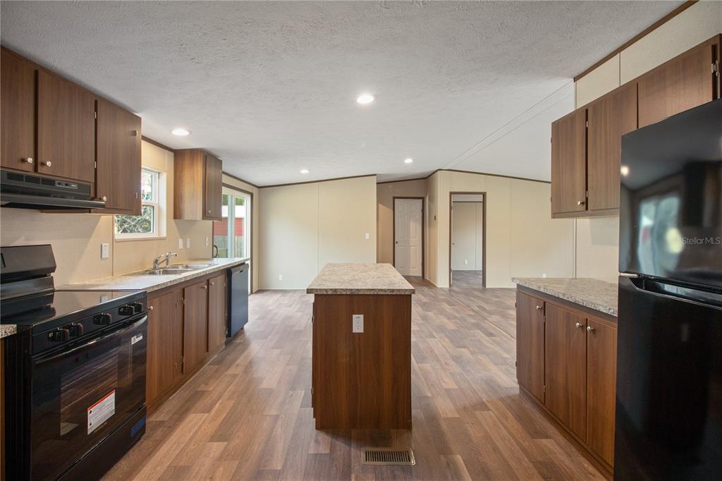 12396 Hicks Road Hudson, FL 34669 - Photo 21 of 33 a kitchen with stainless steel appliances granite countertop a stove a sink and a microwave