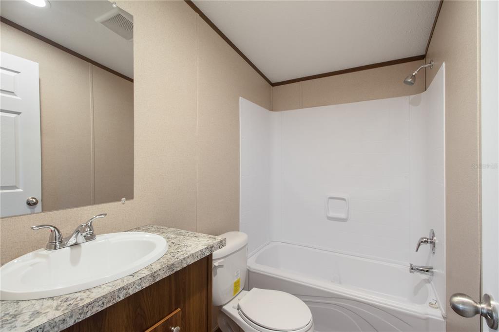 12396 Hicks Road Hudson, FL 34669 - Photo 28 of 33 a bathroom with a granite countertop sink toilet and shower