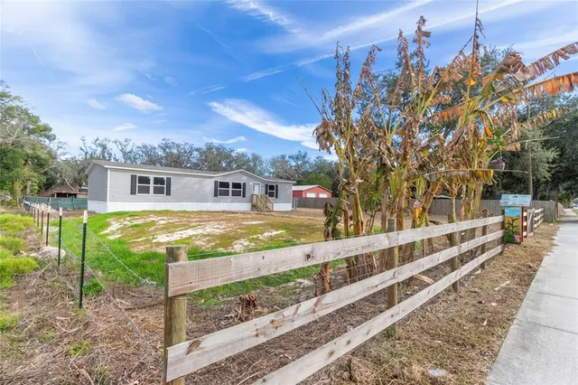 a view of a house with backyard and sitting area