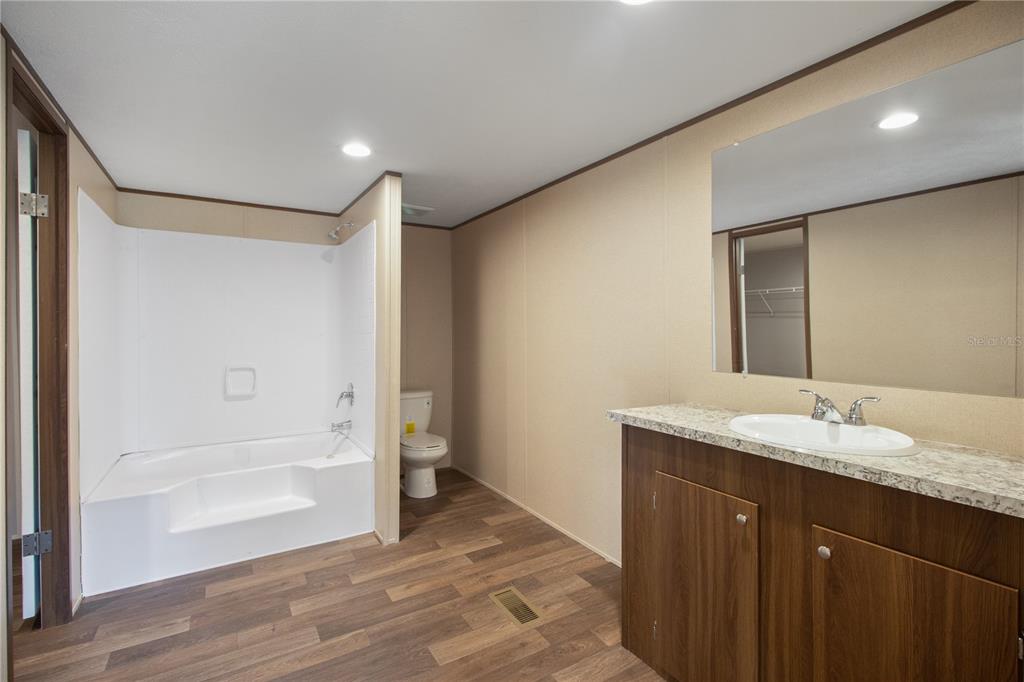 12396 Hicks Road Hudson, FL 34669 - Photo 32 of 33 a bathroom with a granite countertop sink and a mirror