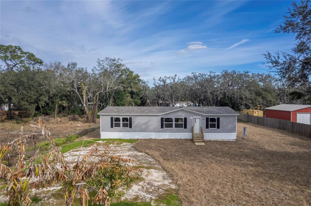 12396 Hicks Road Hudson, FL 34669 - Photo 10 of 33 a view of a house with backyard and trees in the background