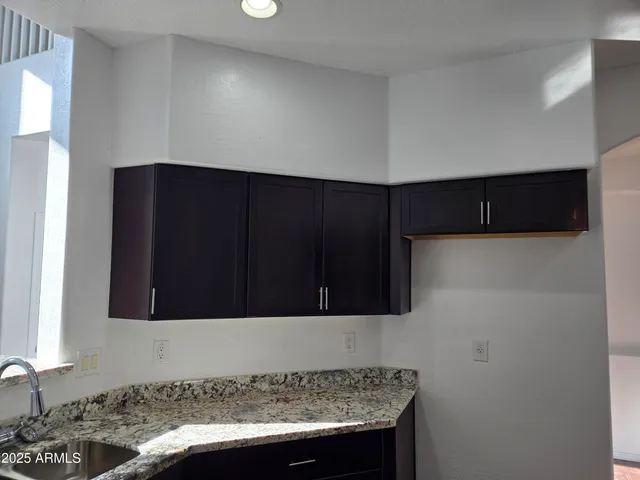 a kitchen with granite countertop wood cabinets and a stove top oven