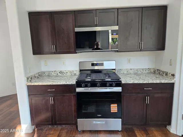 a view of a kitchen with a sink and dishwasher with wooden floor