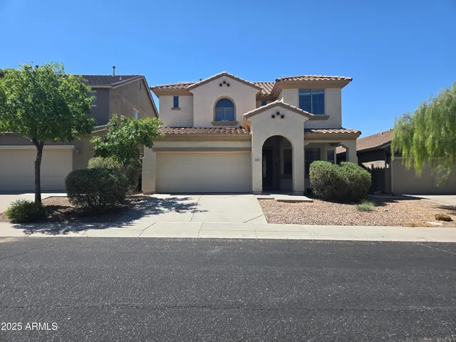 a white house with a large tree in front of it