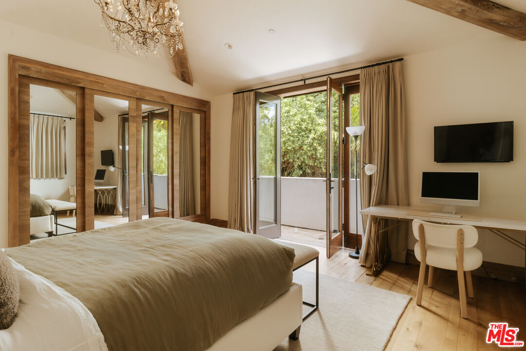 1105 Rivas Canyon Road Pacific Palisades, CA 90272 - Photo 38 of 49 a spacious bedroom with a large bed and a flat tv screen on dresser
