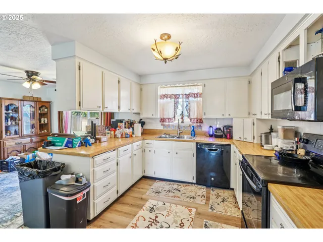 a kitchen that has a lot of cabinets in it and wooden floors