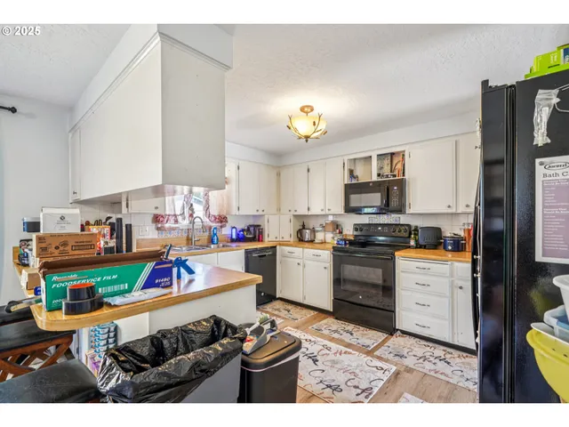 a kitchen with stainless steel appliances kitchen island granite countertop a refrigerator stove and white cabinets
