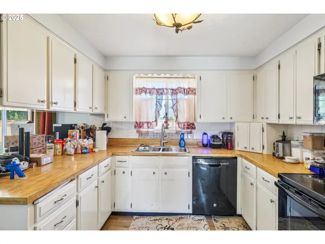 a kitchen with cabinets appliances a sink and a window