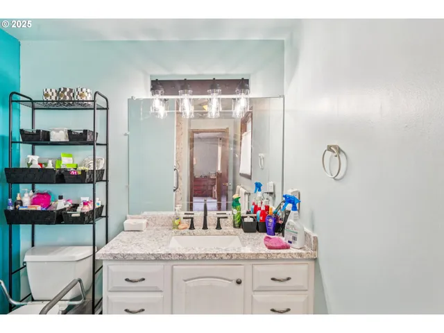 a bathroom with a granite countertop sink a vanity and a large mirror