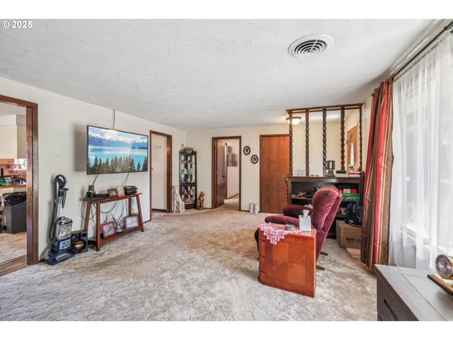 a living room with furniture a large window and gym equipment