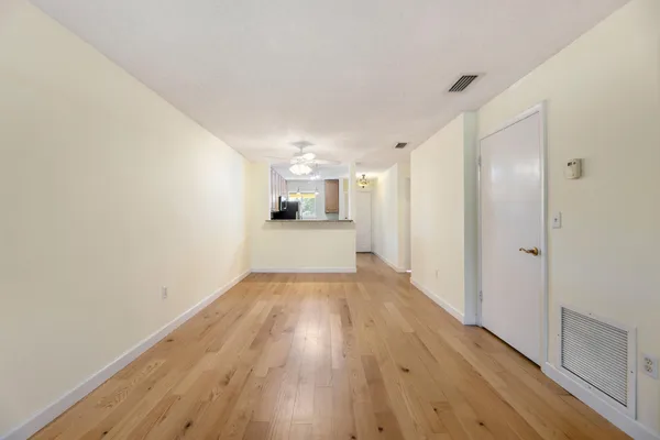a view of empty room with wooden floor