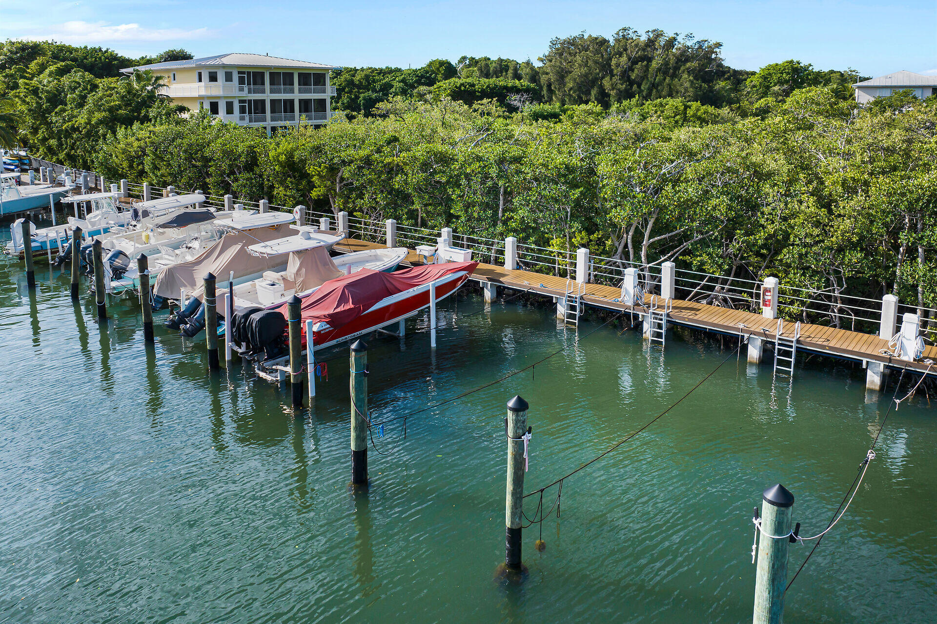 98202 Windward Avenue, Unit CONDO W/ 30 FT BOAT SLIP Key Largo, FL 33037 - Photo 22 of 36 a backyard of a house with yard table and chairs
