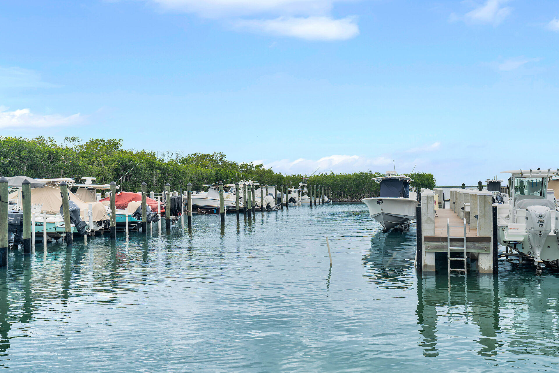 98202 Windward Avenue, Unit CONDO W/ 30 FT BOAT SLIP Key Largo, FL 33037 - Photo 4 of 36 a view of water with boats and trees in all around