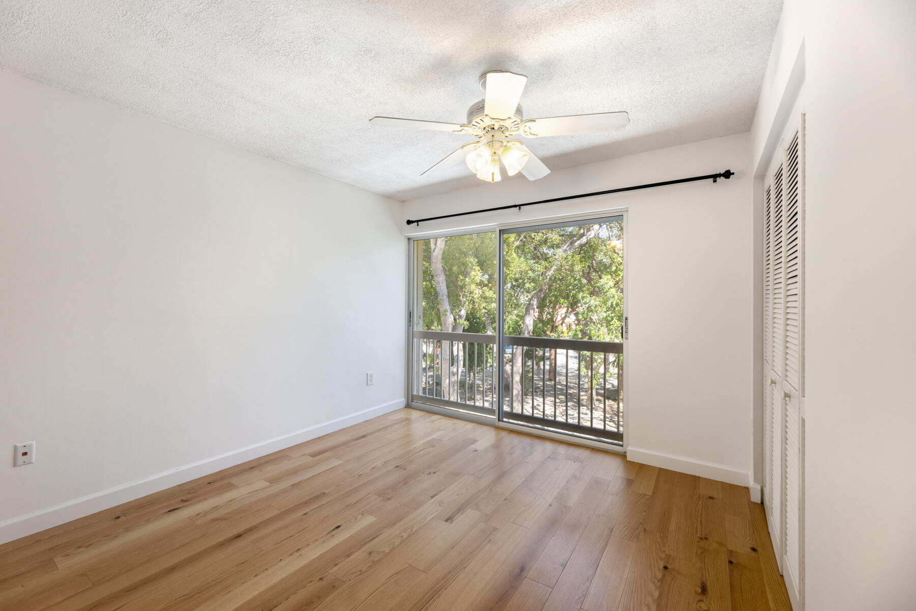98202 Windward Avenue, Unit CONDO W/ 30 FT BOAT SLIP Key Largo, FL 33037 - Photo 8 of 36 a view of an empty room with wooden floor and a window