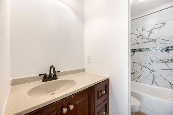 a living room with furniture a ceiling fan and a large window