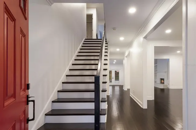 an empty room with windows and fireplace