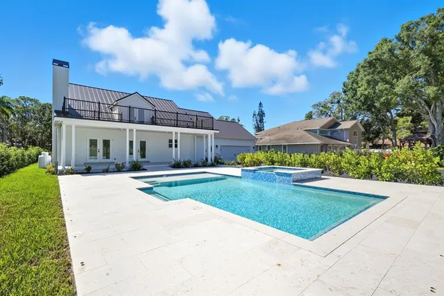 a large white kitchen with wooden floor and a sink