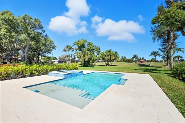a view of a patio with table and chairs potted plants with floor to ceiling window