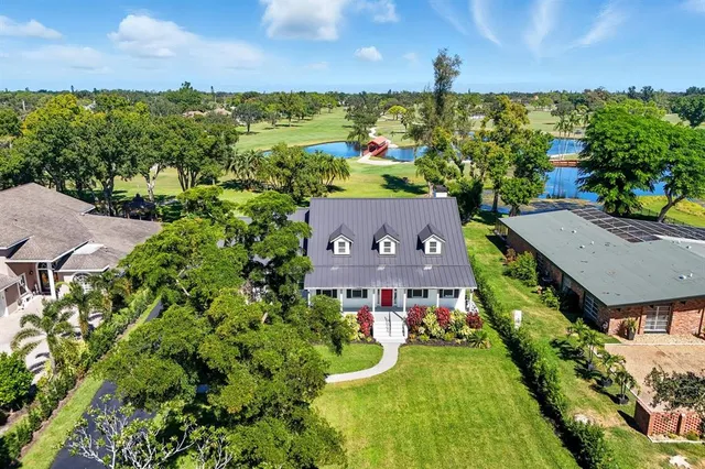 an aerial view of a house with a swimming pool a yard and lake view