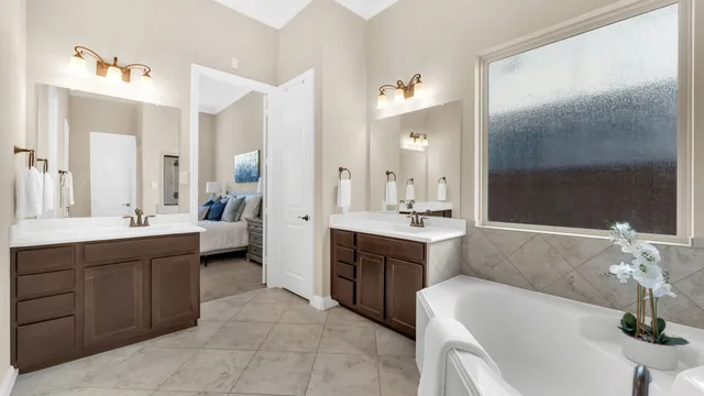 a spacious bathroom with a double vanity sink mirror and bathtub
