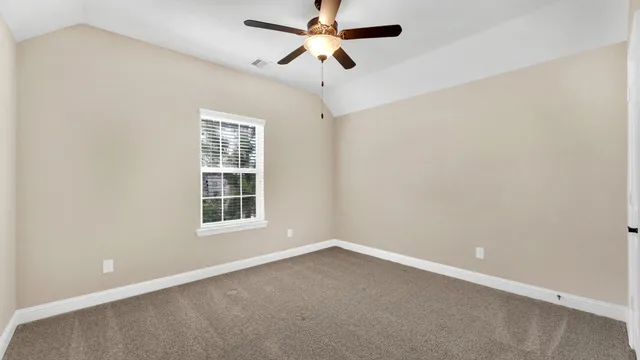an empty room with a window and a fan