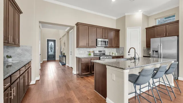 a kitchen with kitchen island granite countertop a sink stove and refrigerator