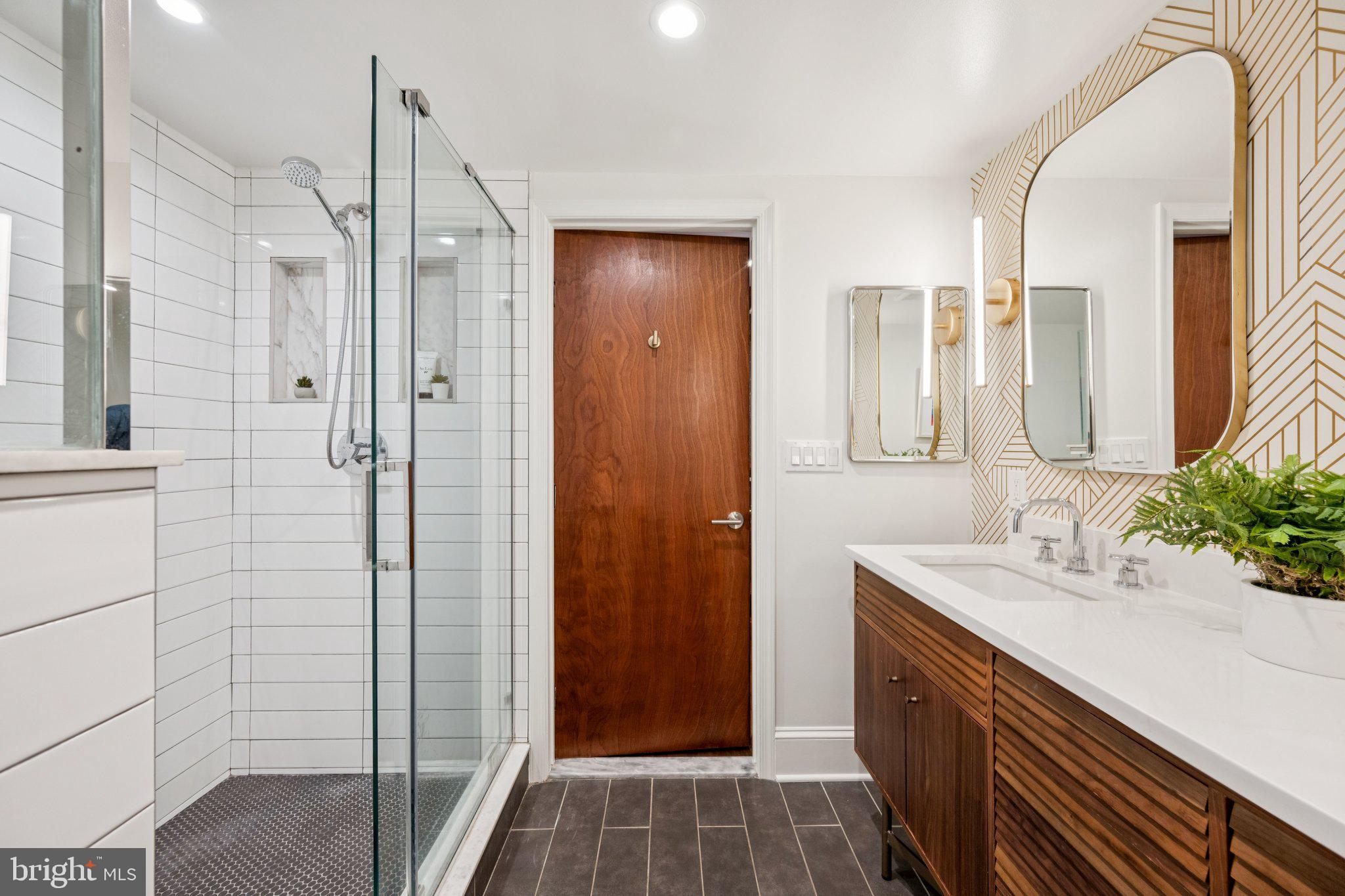 1 Derby Lane Washington, DC 20003 - Photo 21 of 33 a bathroom with a double vanity sink a large mirror and shower