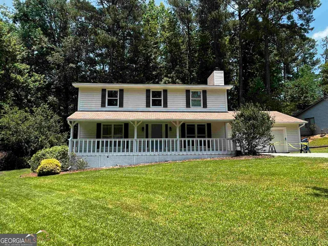 a view of a house with a yard and sitting area