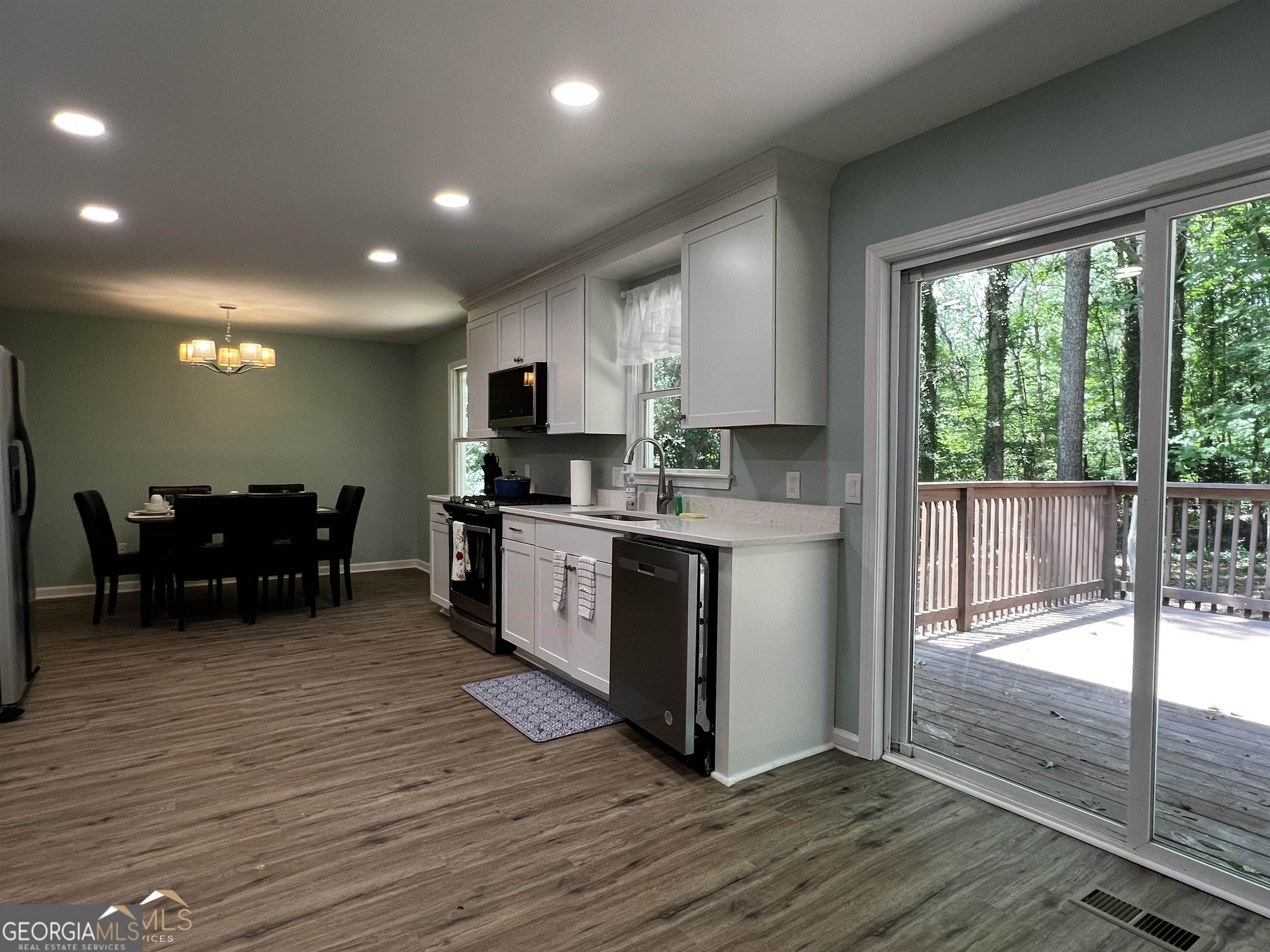 208 Swanson Ridge Peachtree City, GA 30269 - Photo 12 of 40 a kitchen with stainless steel appliances wooden cabinets and dining table