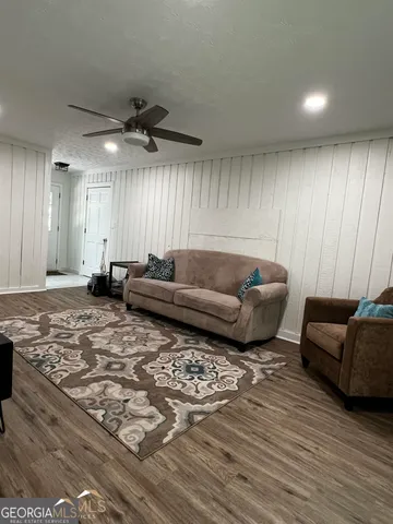 a living room with furniture and a wooden floor