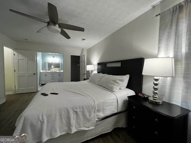 a bedroom with a bed and a lamp on dresser