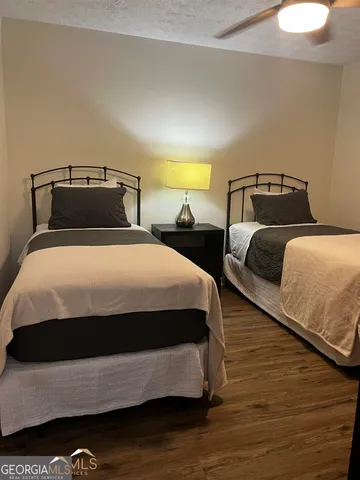 a bedroom with two beds and wooden floor
