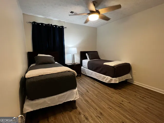 a bedroom with two beds and a ceiling fan