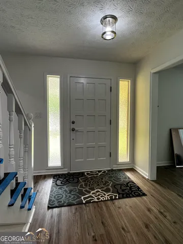 a view of a livingroom with wooden floor and lounge chair