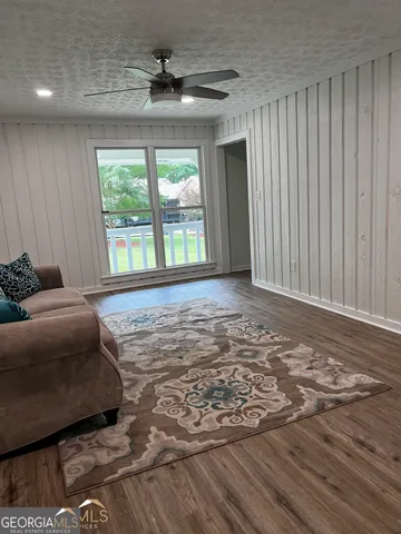 a living room with a bed furniture and a large window