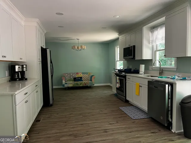 a kitchen with sink a microwave and cabinets