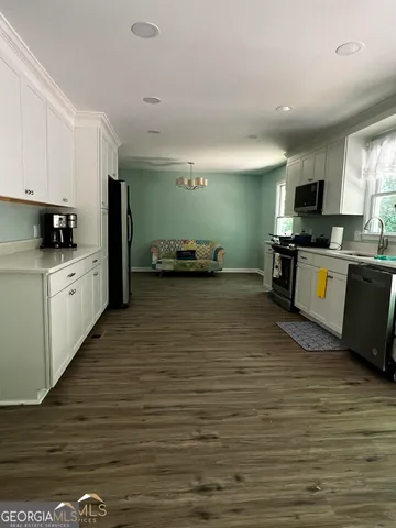 a large kitchen with stainless steel appliances granite countertop a stove and a sink