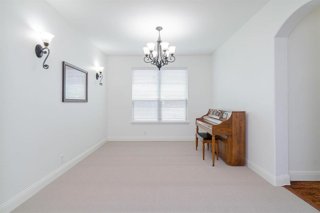 4210 Magnolia Road Melissa, TX 75454 - Photo 10 of 22 Recessed window with blinds, wrought iron chandelier, wall sconces, arched doorway, and carpeted flooring