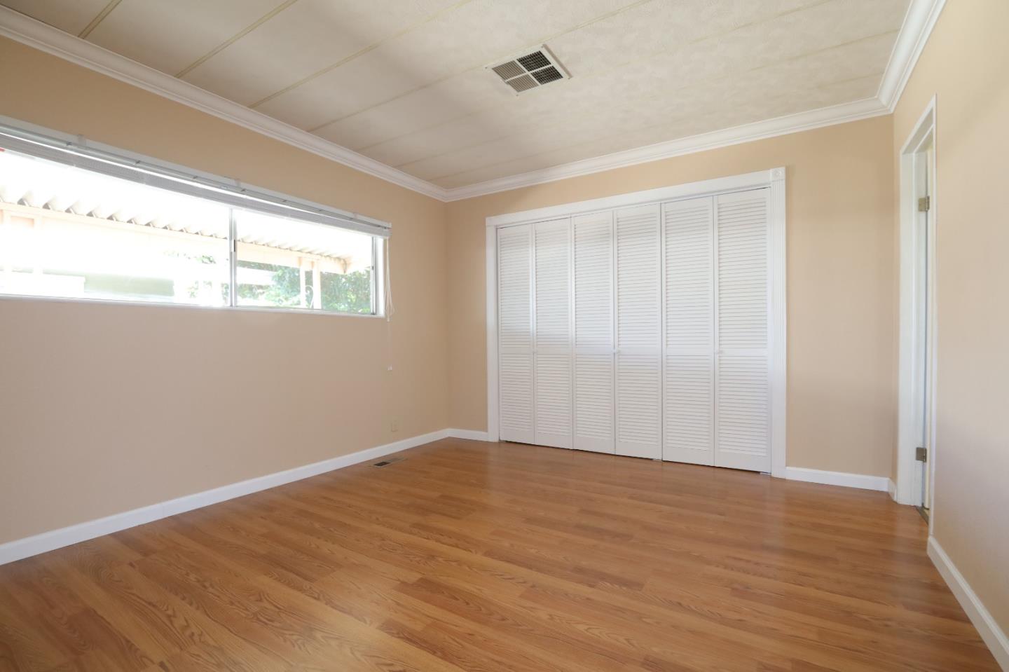 61 Quail Hollow Drive, Unit 61 San Jose, CA 95128 - Photo 22 of 36 a view of an empty room with wooden floor and a window