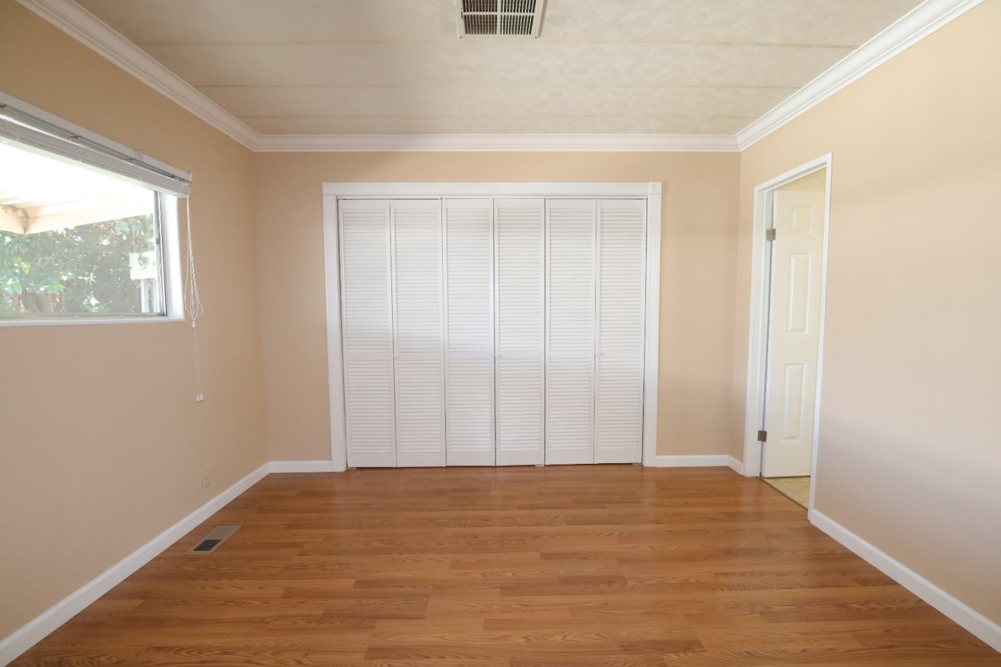 61 Quail Hollow Drive, Unit 61 San Jose, CA 95128 - Photo 24 of 36 a view of an empty room with wooden floor and a window