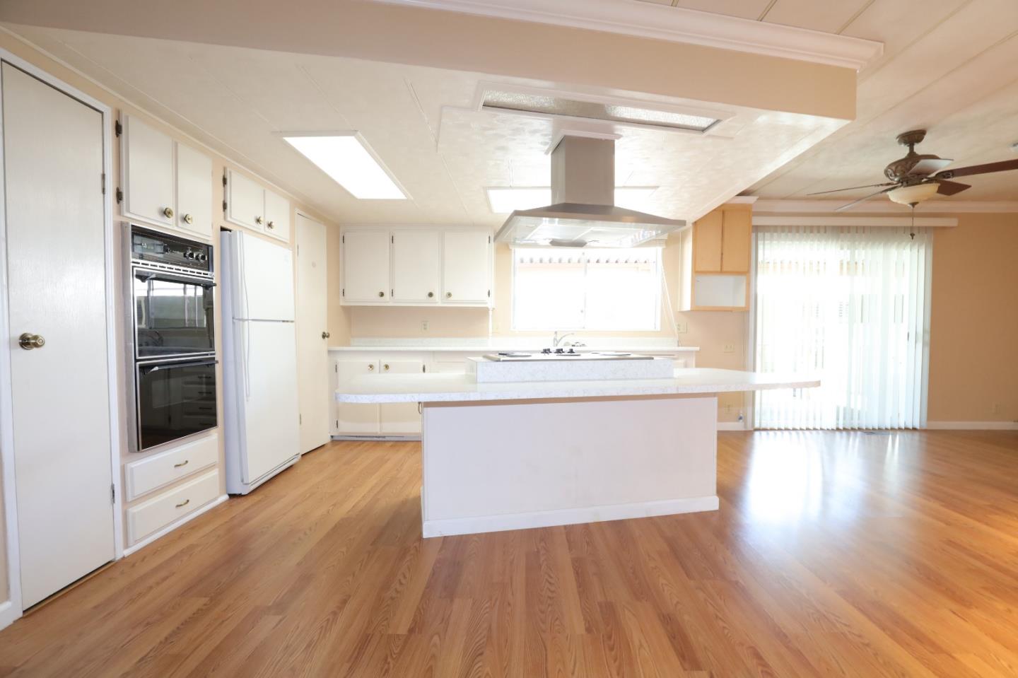 61 Quail Hollow Drive, Unit 61 San Jose, CA 95128 - Photo 7 of 36 a large kitchen with stainless steel appliances a large counter top a stove and a refrigerator
