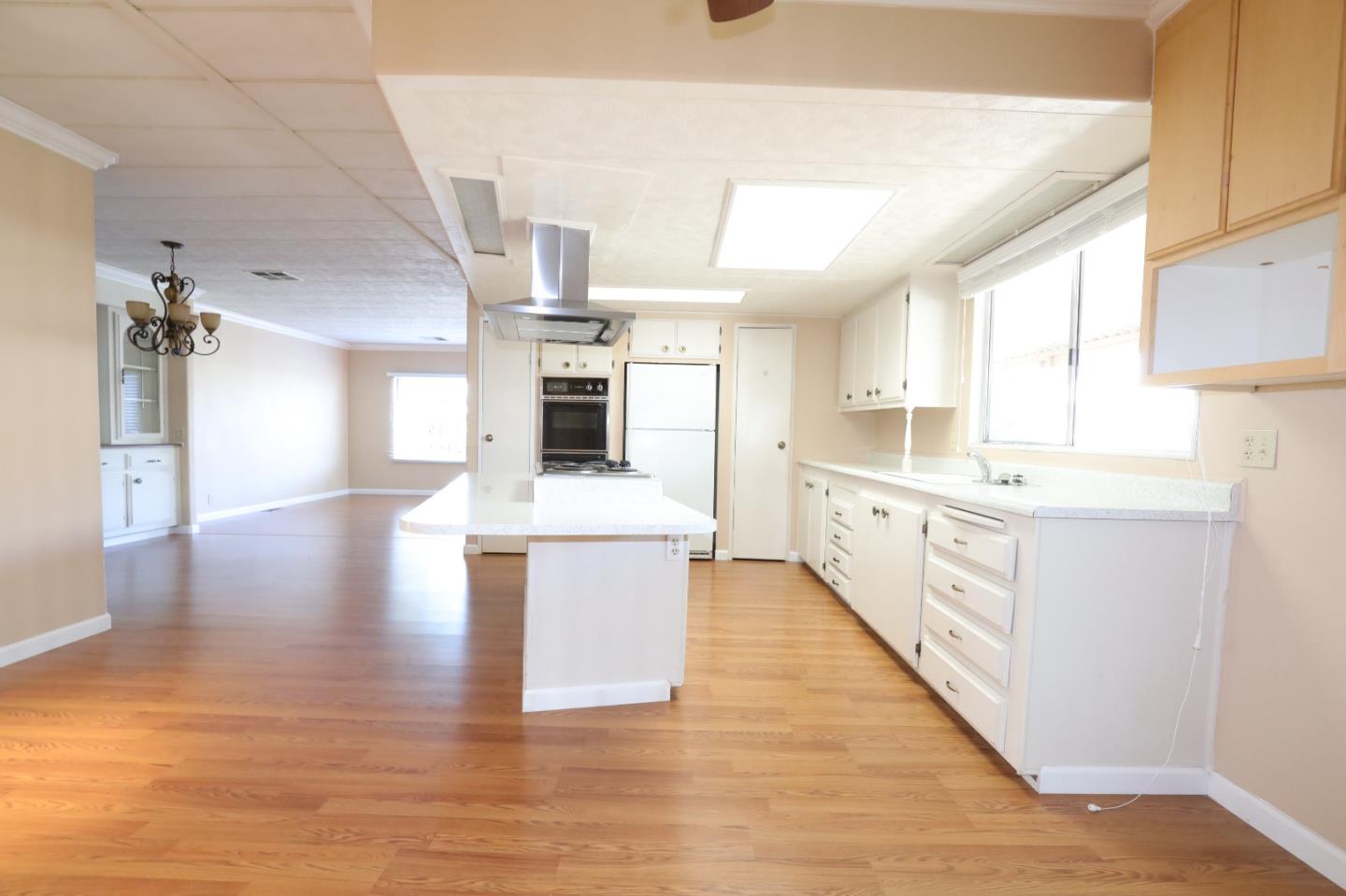 61 Quail Hollow Drive, Unit 61 San Jose, CA 95128 - Photo 9 of 36 a kitchen with stainless steel appliances kitchen island wooden floors and white cabinets