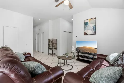 a living room with furniture ceiling fan and a wooden floor