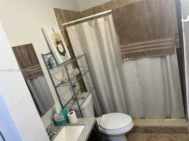 a white toilet sitting next to a shower curtain